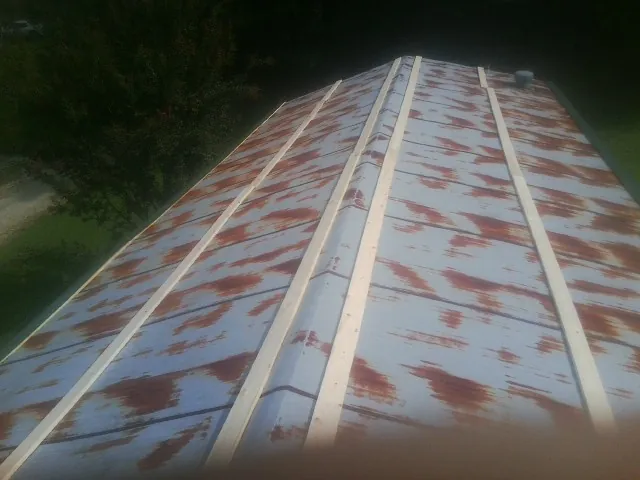 Rusted metal roof panels with new wood purlins before replacement — Storm Damage Roof Repair in Zenia by Roofing Brothers